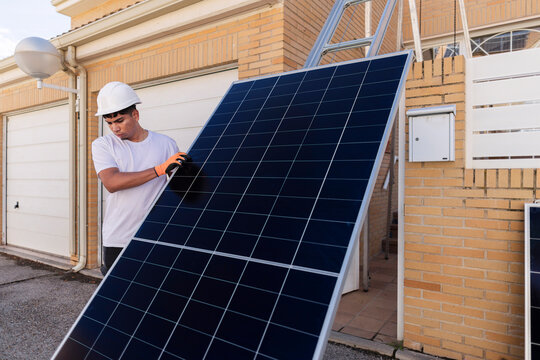 Worker installing solar panel for sustainable energy solution