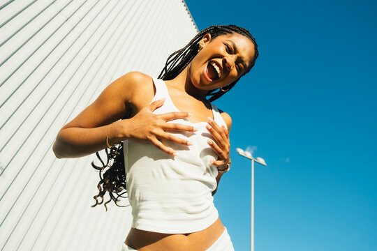 Young woman showing sneaker sole in playful urban portrait
