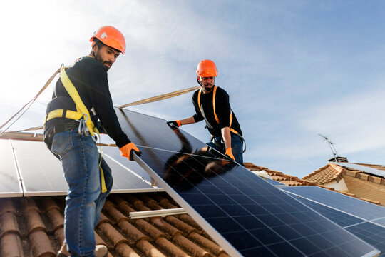 Installers working on rooftop installing solar panels for