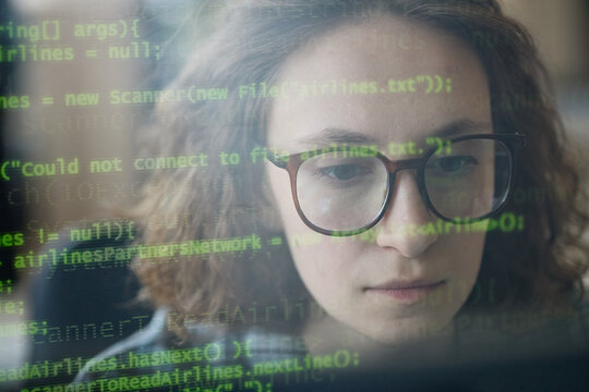 Young adult Caucasian woman analyzing computer code through screen overlay, focusing on software development and debugging. Ideal for cybersecurity, programming, tech careers marketing