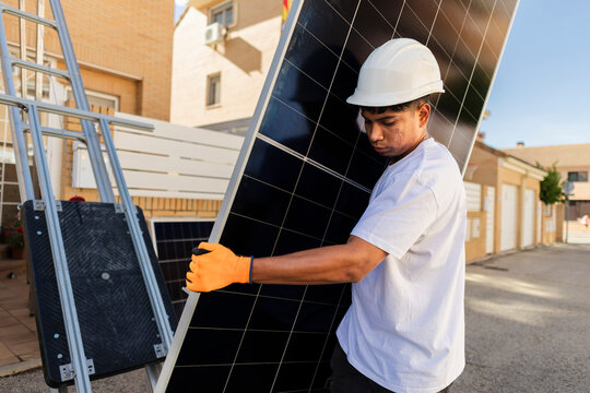 Technician working carrying solar panel for sustainable energy