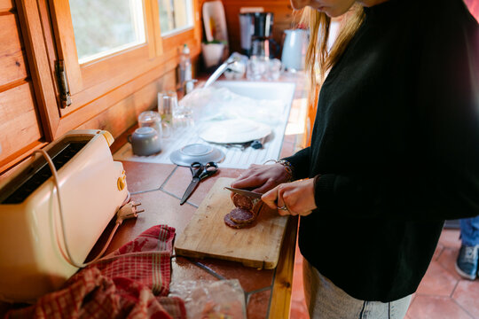 Young woman cutting saucisson ( salami) in France