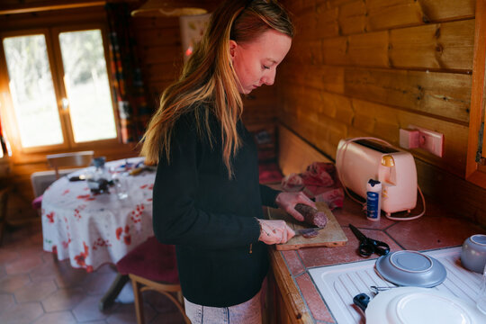 Young woman cutting saucisson ( salami) in France