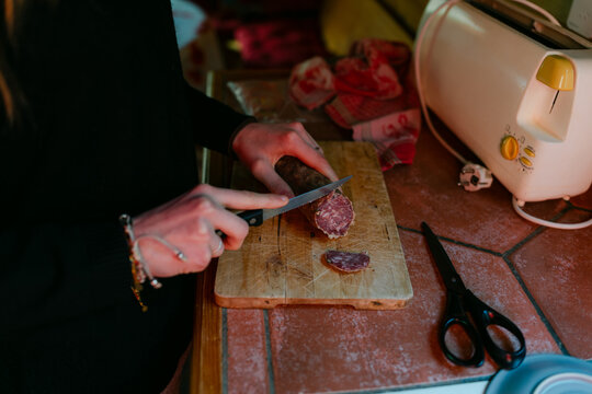 Young woman cutting saucisson ( salami) in France