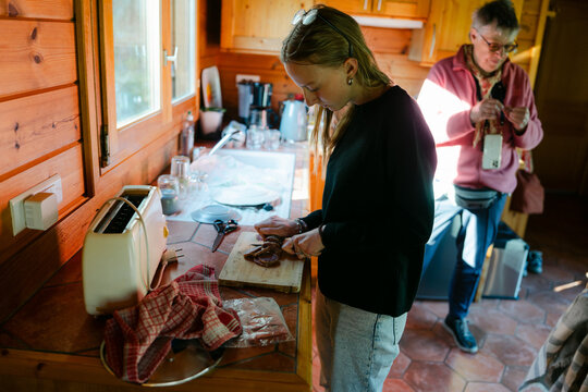 Young woman cutting saucisson ( salami) in France