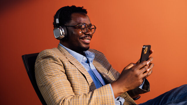 Smiling Man in Headphones Using Smartphone 