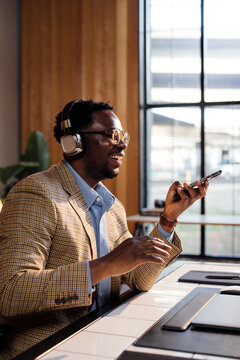 Smiling Man Using a Phone and Sending a Voice Message