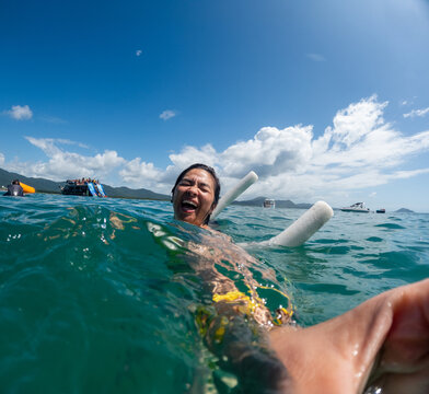 UGC Woman Enjoying Warm Water While Swimming in Ocean Near Boats