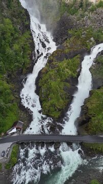 Aerial portrait drone vertical reveal of Latefossen with highway, Norway