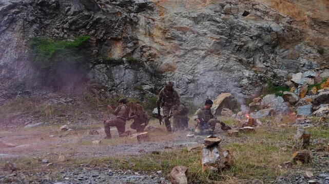 A group of soldiers in military uniforms were seen holding BB guns, cleaning their weapons and resting during a patrol while exercising their military training, playing games