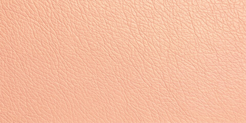 Fototapeta premium Close-up macro shot of the natural textured grain of light peach leather, showcasing its fine pores and subtle sheen. A luxurious, soft, and organic material perfect for fashion and interior design.