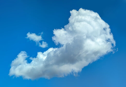 Caravel-shaped cloud, flying full speed, being torn apart strong wind. Dynamic image diagonal flight. Clear, formed clouds of white cumulus vapor on clear blue sky. Complex texture structure curly.