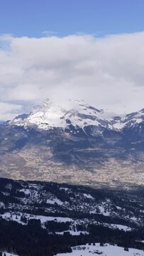 A sweeping aerial view of the snow-covered mountains and valleys in the Sallanches, Passy, and Mont Blanc region of the French Alps. The footage captures dramatic peaks, scattered evergreen forests
