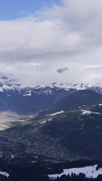A sweeping aerial view of the snow-covered mountains and valleys in the Vallee de Sallanches, Passy, and Mont Blanc region of the French Alps. The footage captures dramatic peaks, forested slopes