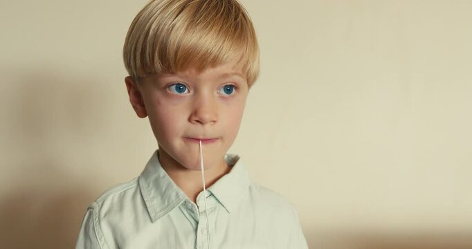 Boy pulling out first baby tooth with string