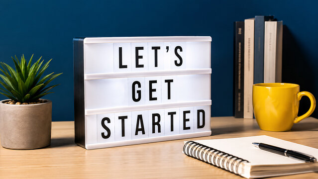 Let's Get Started text on light box sign board on wooden desk with plant and coffee cup, motivation, startup business kickoff, new project initiation, workplace inspiration