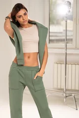 Portrait of a confident young woman wearing a trendy tracksuit  standing in a minimalist studio. Modern casual streetwear, athleisure fashion, comfortable outfit, urban style © neonshot