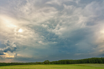 Dramatic storm clouds over green countryside landscape before rain © Orbs production