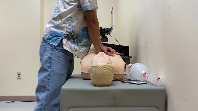 Man Practicing Chest Compressions & Ventilation Rescue Breaths with Ambu Bag on Dummy Doll, Demonstrating CPR training