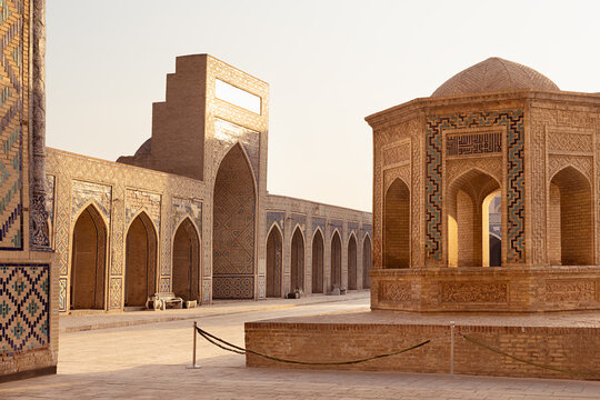 Courtyard of Kalyan Mosque in Bukhara with arcaded galleries and octagonal pavilion bathed in golden light. Ideal for travel, heritage, and cultural publications about Uzbekistan and the Silk Road.