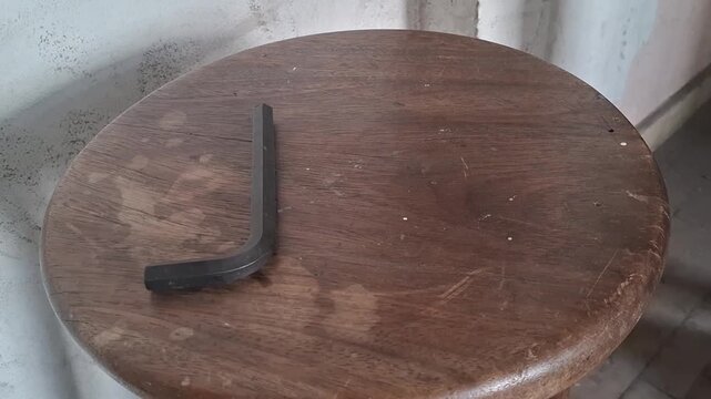 Hand placing metal hex keys on wooden stool video footage clip