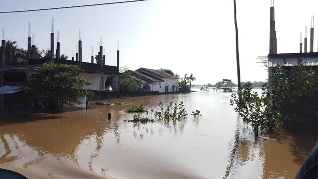 Severe flooding submerging residential houses in a rural village landscape