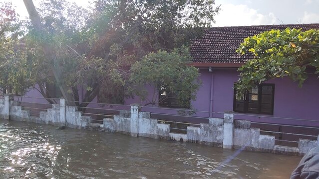Flooded residential house with purple walls surrounded by rising water levels