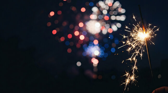 Sparkler firework celebration night bokeh sparkle Burning sparkler glowing bright beside colorful firework bokeh dark night sky, festive celebration background with warm light, excitement