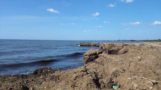 Rocky Coastal Shoreline with Gentle Ocean Waves Under Clear Blue Sky