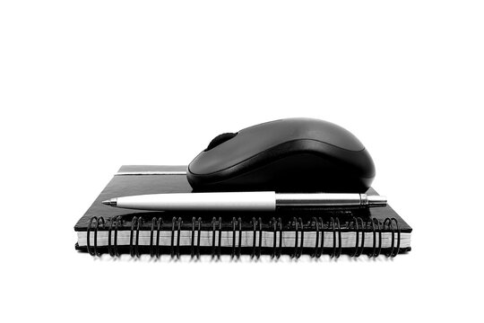 Computer mouse, notebook, and pen isolated on a white background in black and white. Business and school concept.
