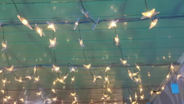 Twinkling star-shaped fairy lights strung across a green ceiling