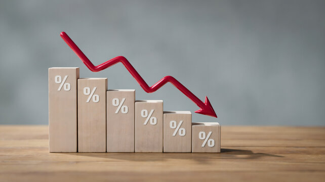 Decreasing percentage sign on wooden blocks with a red arrow showing a downward trend on a wooden table