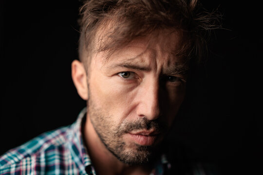 Intense serious man in plaid shirt looking forward