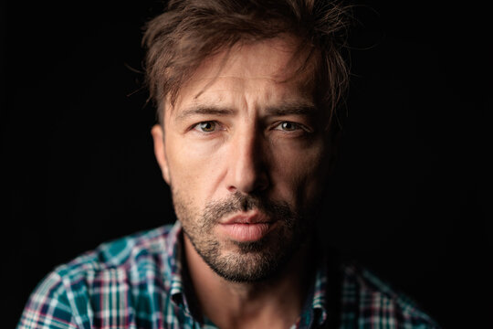 Brooding bearded man with messy hair staring forward