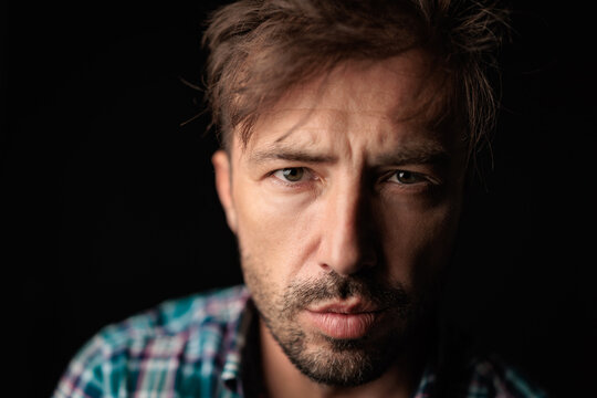 Serious man in casual checkered shirt looking forward