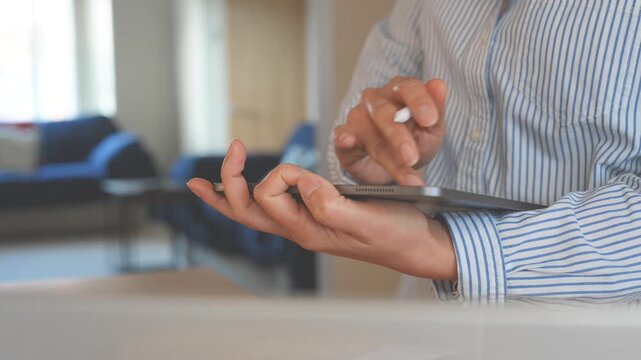 Person typing on tablet with stylus in modern workspace. Digital note taking, online communication, mobile productivity, remote work and business technology concept.