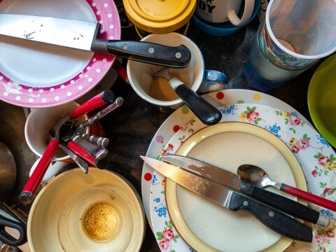 Dirty washing up piled up ready to be cleaned.