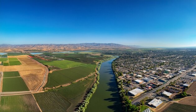 scenic aerial view of modesto california showcasing lush farmlands urban landscapes and the beautiful tuolumne river under a clear blue sky
