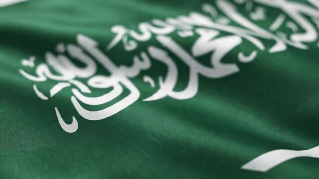 Saudi Arabian flag with detailed Arabic script and green background, symbolizing national identity and cultural heritage in a vibrant, close-up view.