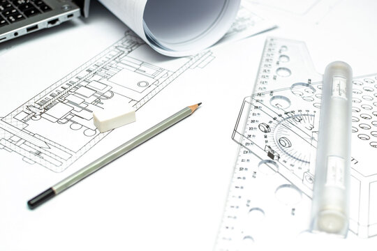 Architectural or electrical schematic diagram blueprint on a table with professional drafting tools, plastic rulers, an eraser, and a graphite pencil