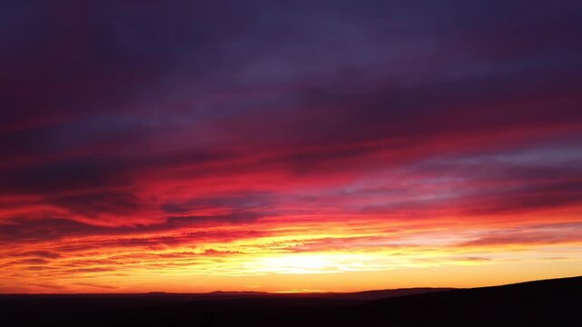 Vibrant orange sunset clouds at horizon.