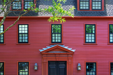 Fototapeta premium Symmetrical red house front with multi-pane windows and dark shingled roof in Charlestown, Boston, USA 