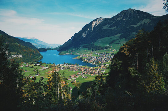 Aerial view of Swiss alpine town beside turquoise mountain lake