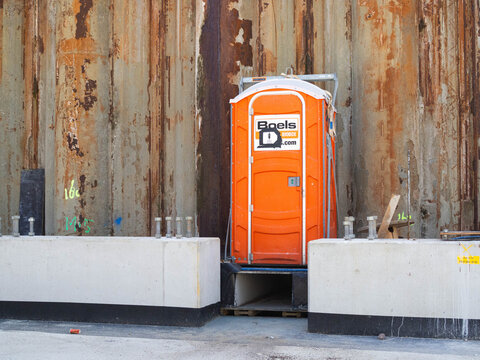 Boels portable toilet between concrete barriers at A9 road construction site with rusty sheet pile retaining wall for Amsterdam highway ring road works, 25 June 2026, Amstelveen, The Netherlands