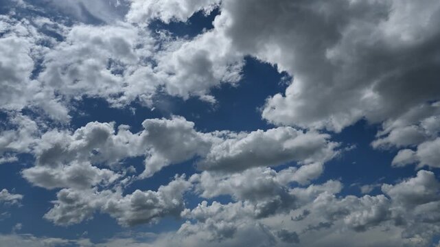 Time lapse of puffy white cumulus clouds churning in a blue sky