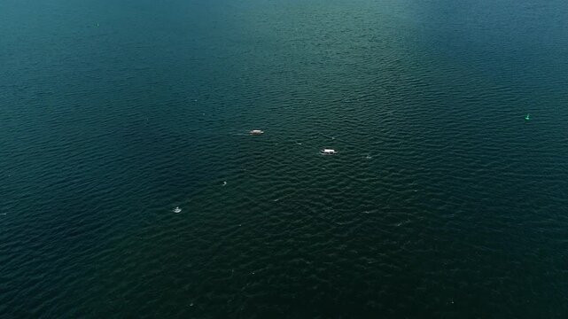 Aerial drone view of traditional outrigger boats sailing across tropical blue ocean. Ideal for travel and nature themed concepts.