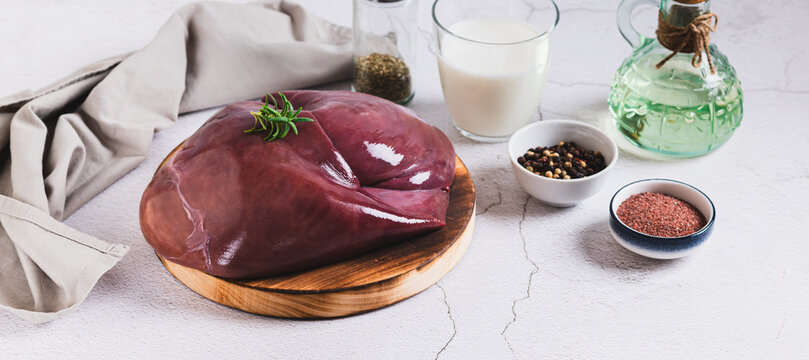 Fresh beef liver on a cutting board on the table web banner