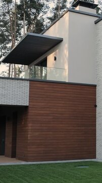 Vertical video. Modern glass balcony with slatted roof on contemporary private house exterior.
