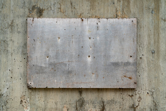 blank weathered sign on a grunge and rough concrete wall