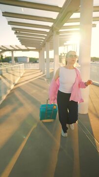 Caucasian woman pulling a suitcase and running, late for flight.